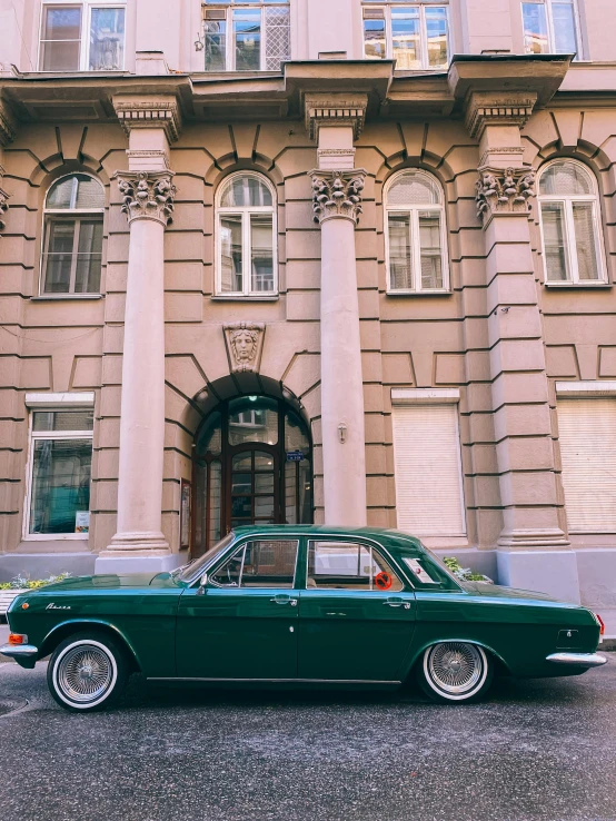 a green car is parked in front of a building, a photo, by Emma Andijewska, pexels contest winner, renaissance, soviet style, profile image, 🚿🗝📝, mid body