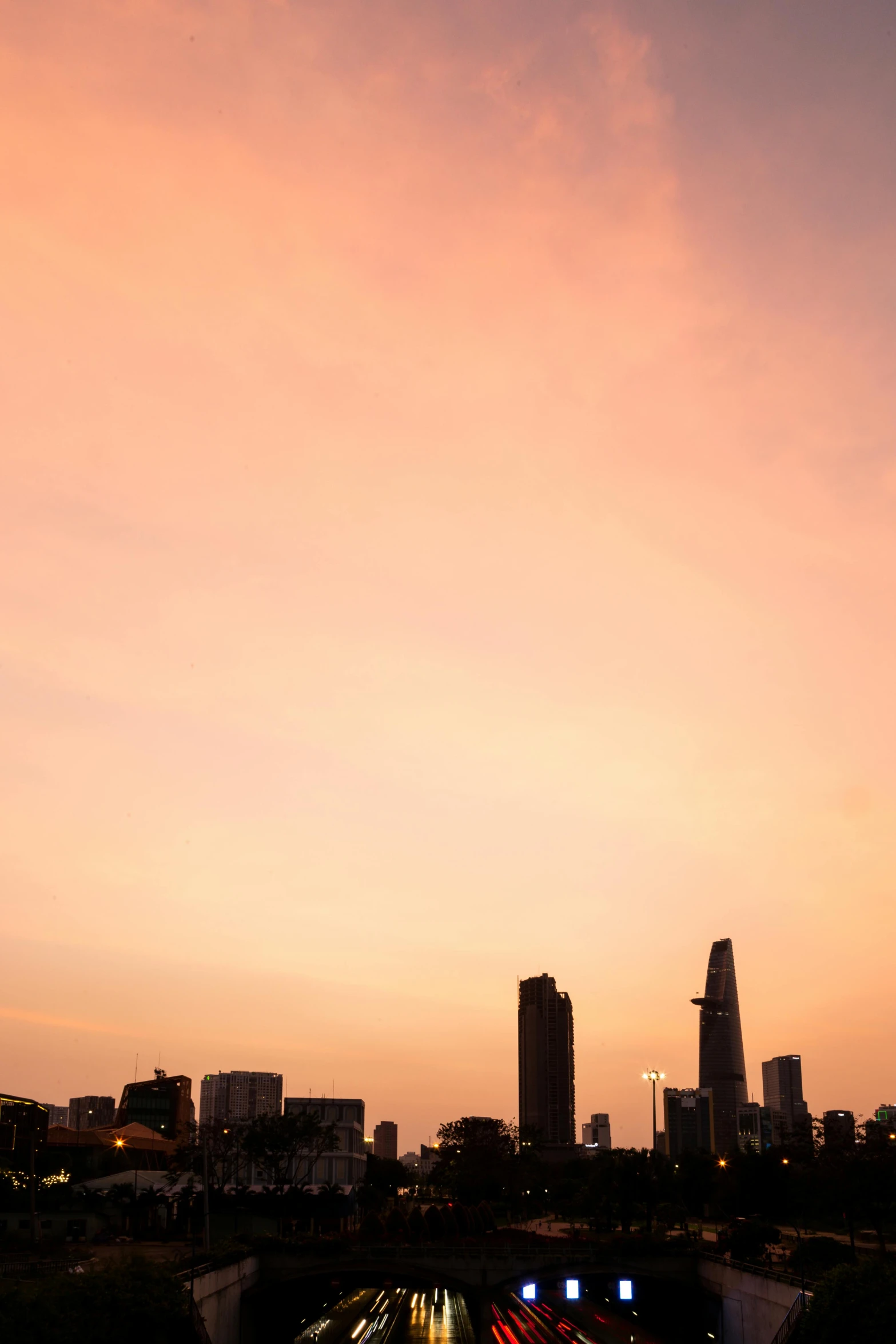 a view of a city at sunset from a bridge, by Sven Erixson, minimalism, vietnam, tall minimalist skyscrapers, high res photograph, pastel'