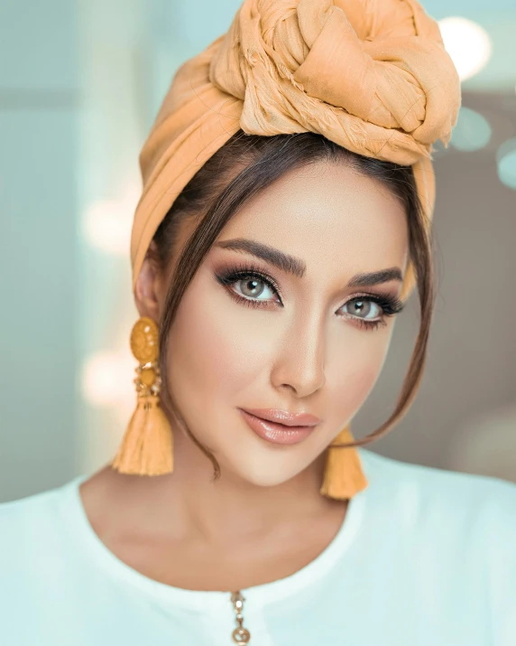 a woman with a turban on her head, inspired by Maryam Hashemi, trending on instagram, her skin is light brown, influencer, official product photo, looking directly at the camera
