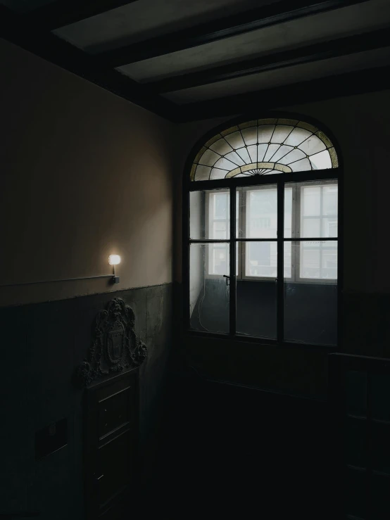 a light shines through a window in a dark room, dark academia aesthetics, snapchat photo, black windows, dark and muted colors
