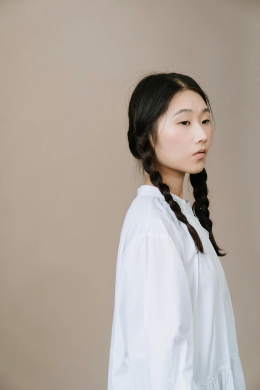 a woman with long black hair wearing a white shirt, inspired by Kim Tschang Yeul, trending on pexels, hyperrealism, two braids, minimal clothing, ethnicity : japanese, androgynous person