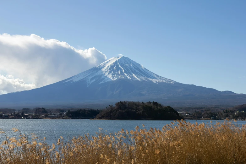 a large mountain towering over a body of water, a picture, trending on unsplash, sōsaku hanga, fuji choko, avatar image, 🚿🗝📝