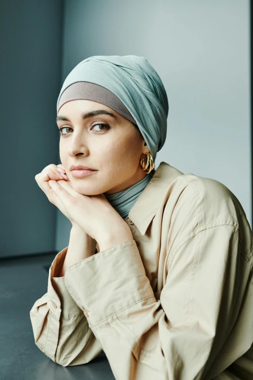 a woman in a turban poses for a picture, inspired by Maryam Hashemi, trending on pexels, hurufiyya, cool toned, magdalena andersson, looking left, official store photo