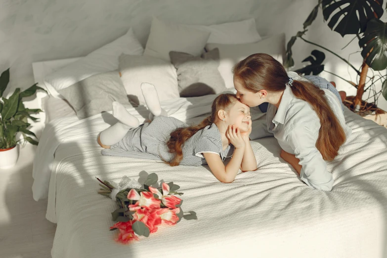 a woman laying on top of a bed next to a little girl, pexels contest winner, romanticism, sitting with flowers, 15081959 21121991 01012000 4k, kissing each other, premium quality