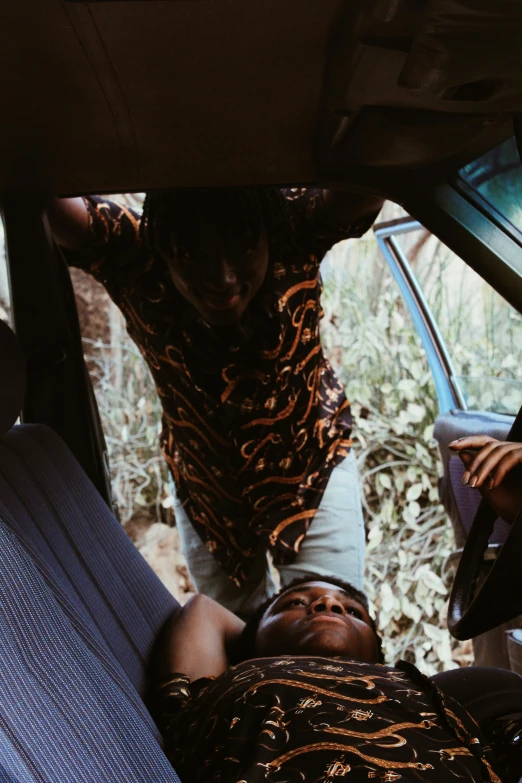 a man laying in the back seat of a car, an album cover, by Elsa Bleda, happening, in africa, an ahoge stands up on her head, teenage boy, high view