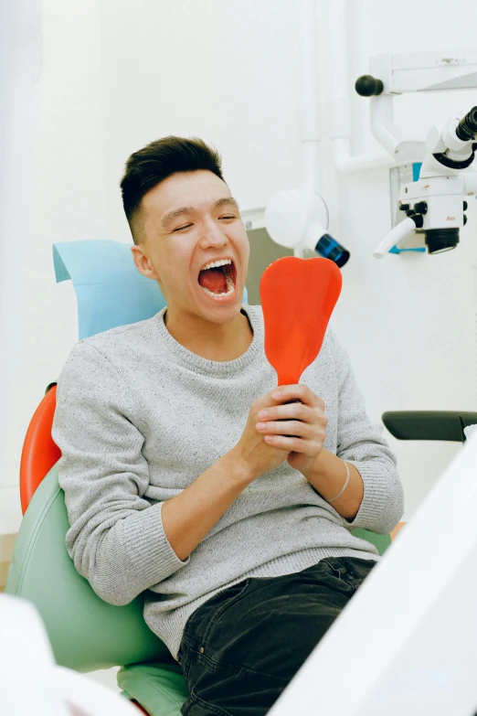 a man laughing while sitting in a dental chair, inspired by Tooth Wu, happening, holding maracas, coloured photo, handsome chad chin, tooth wu : : quixel megascans