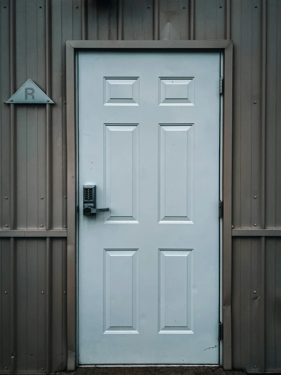 a white door sitting on the side of a building, by Ryan Pancoast, 8 k image, metal key for the doors, inside a shed, detailed product image