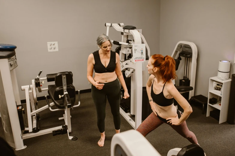 a couple of women standing next to each other in a gym, by Meredith Dillman, pexels contest winner, arched back, lower body, oc, full body picture