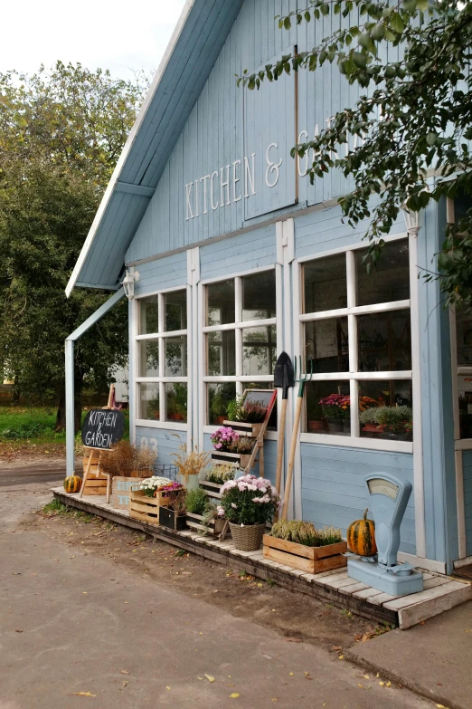 a blue building sitting on the side of a road, cute kitchen, exterior botanical garden, the store, mittens