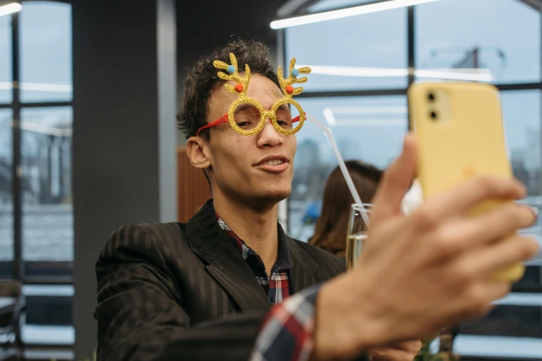 a man taking a picture of himself with a cell phone, pexels contest winner, gold and yellow notched antlers, having a cool party, avatar image, christmas