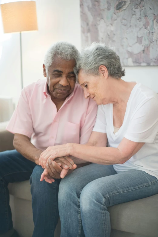 a man and a woman sitting on a couch, holding each other hands, dementia, varying ethnicities, going gray