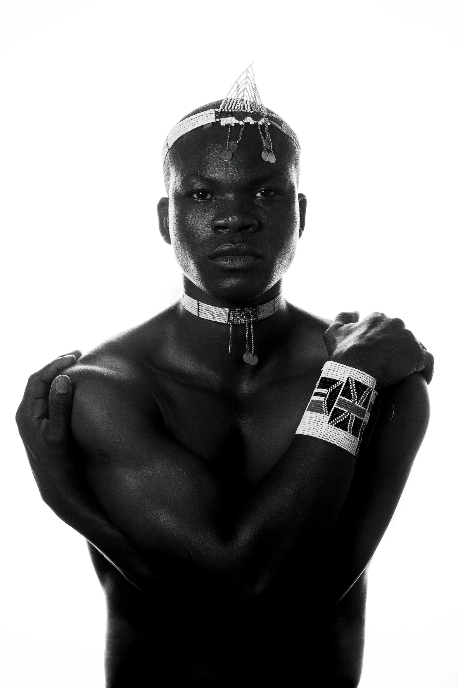 a black and white photo of a man with a crown on his head, an album cover, inspired by David Bailly, afrofuturism, massai warrior, a black choker, beefcake pose, ( ( dark skin ) )