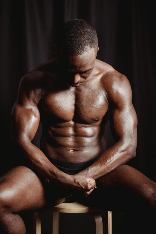 a man sitting on top of a stool, by Cosmo Alexander, pexels contest winner, renaissance, athletic body build, deep black skin, detailed veiny muscles, chest