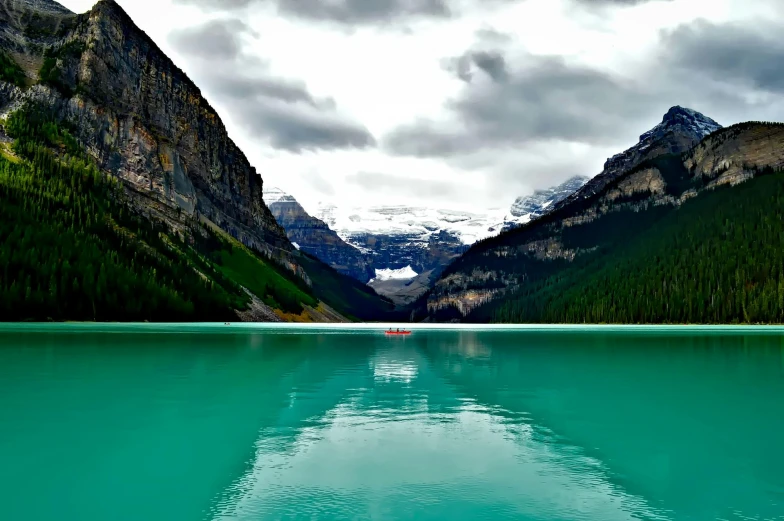 a large body of water with mountains in the background, pexels contest winner, banff national park, floating. greenish blue, small canoes, conde nast traveler photo