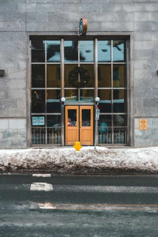 a yellow fire hydrant sitting in front of a building, pexels contest winner, vancouver school, nesting glass doors, snow outside the windows, symmetrical doorway, gif