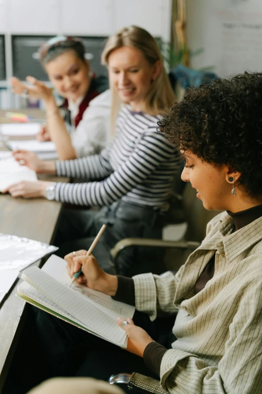 a group of women sitting around a wooden table, trending on pexels, academic art, in a school classroom, thumbnail, writing on a clipboard, banner