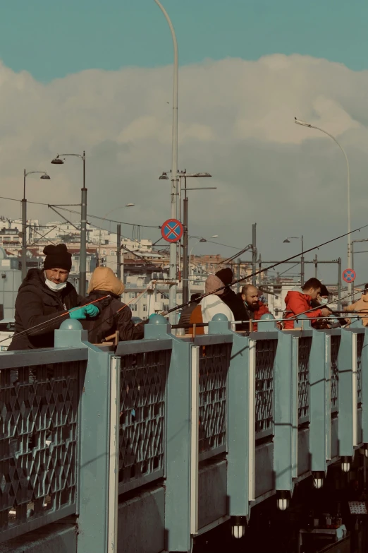 a group of people standing on top of a bridge, a colorized photo, by Attila Meszlenyi, pexels contest winner, fish seafood markets, banner, istanbul, people are wearing masks