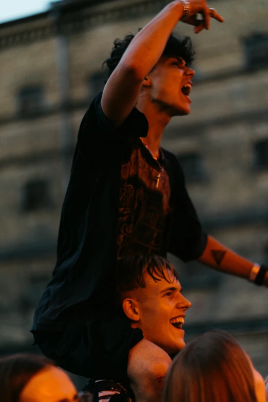 a man riding on the back of a woman's shoulders, an album cover, by Attila Meszlenyi, pexels contest winner, punk concert, on rooftop, celebrate goal, two young men