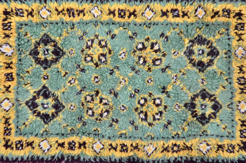 a close up of a rug on a table, inspired by William Morris, arabesque, teal headband, game top down view, yellow and black trim, shag