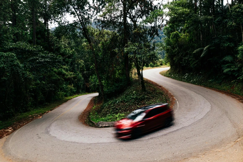 a red car driving down a winding road, malaysia jungle, avatar image, conde nast traveler photo, in australia