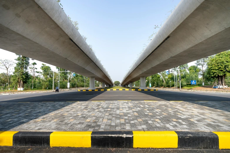 a black and yellow brick road under a bridge, unsplash, hyperrealism, beautiful futuristic new delhi, square lines, 8k resolution”, concrete pillars