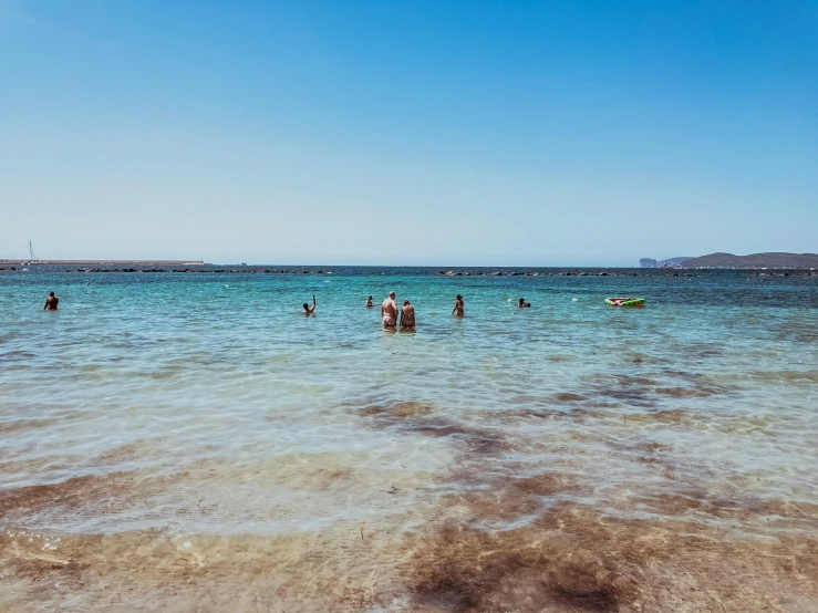 a group of people swimming in a body of water, by Julia Pishtar, pexels contest winner, mediterranean beach background, low quality photo, thumbnail, brown