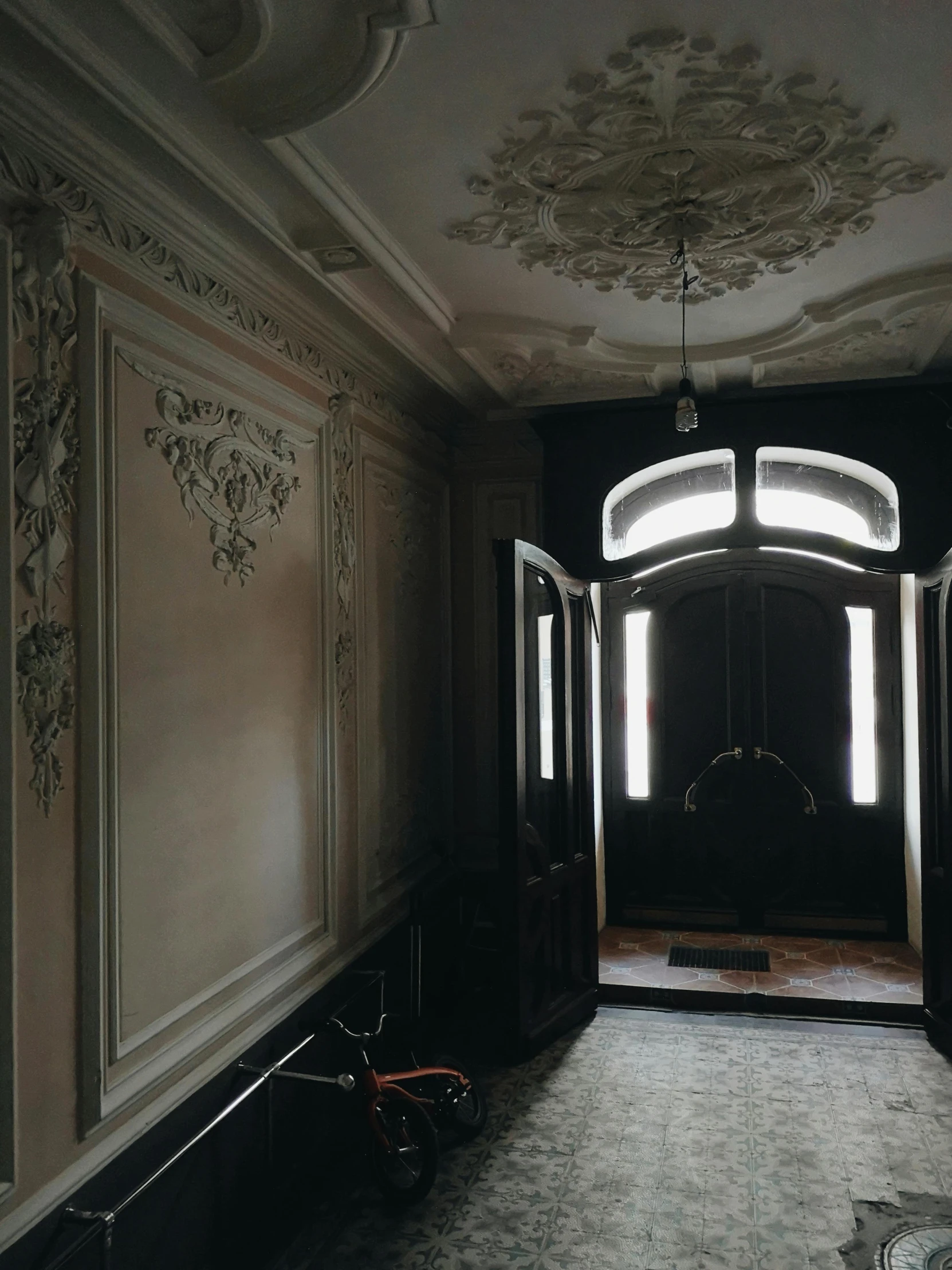 a black and white photo of a hallway, inspired by Luis Paret y Alcazar, unsplash contest winner, art nouveau, dark and beige atmosphere, seen from outside, in a old house. hyper realistic, paneled walls