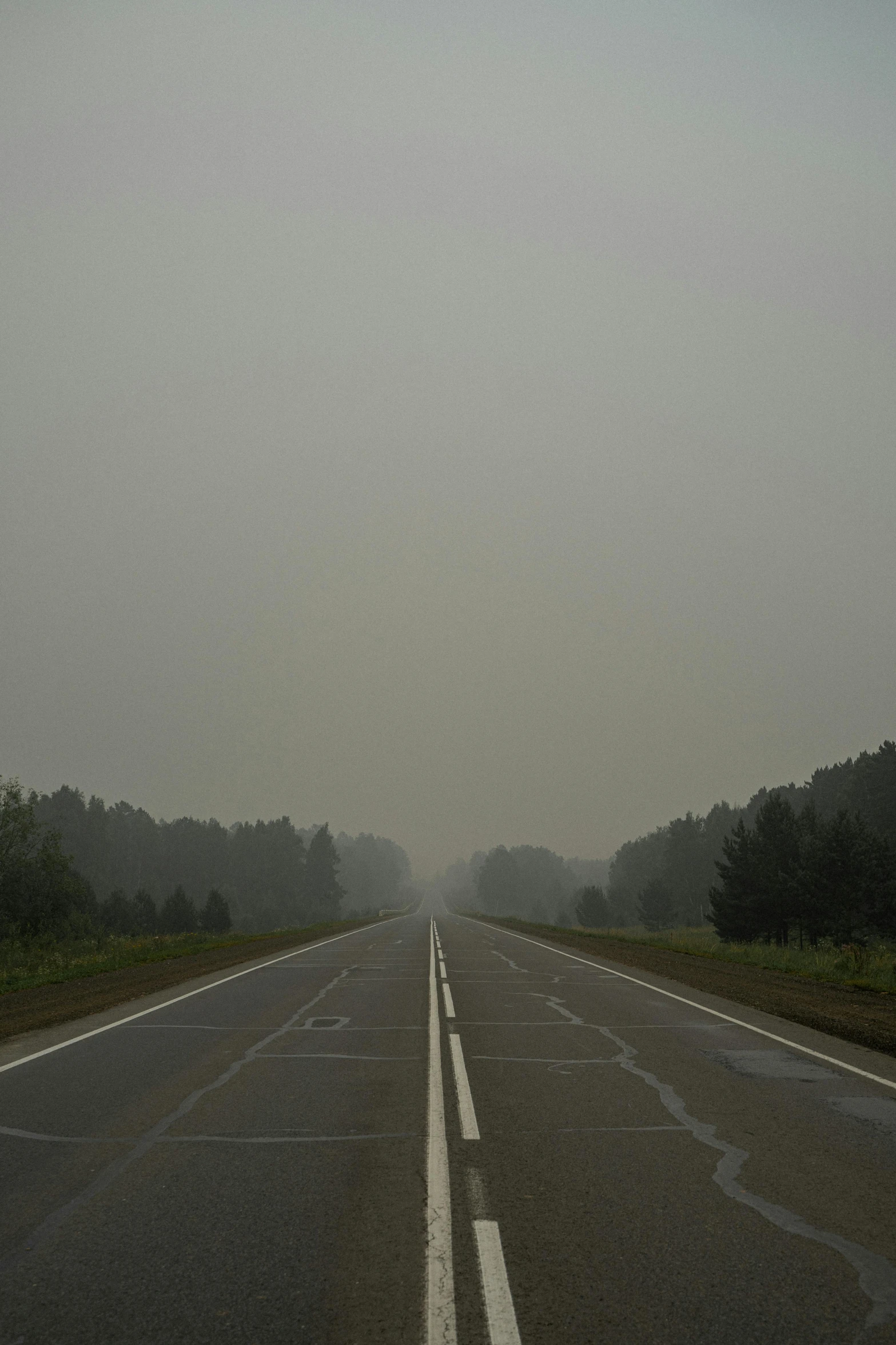 an empty highway on a foggy day, an album cover, by Attila Meszlenyi, romanticism, forest fires in the distance, siberia!!, 2010s, empty streetscapes