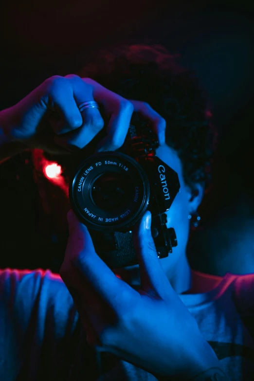 a person taking a picture with a camera, inspired by Elsa Bleda, blue and red lighting, avatar image, canon shot, event photography