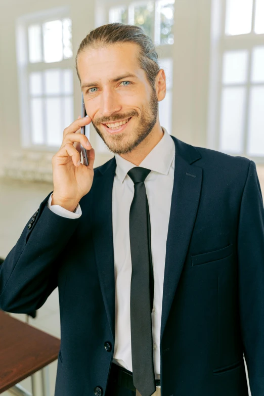 a man in a suit talking on a cell phone