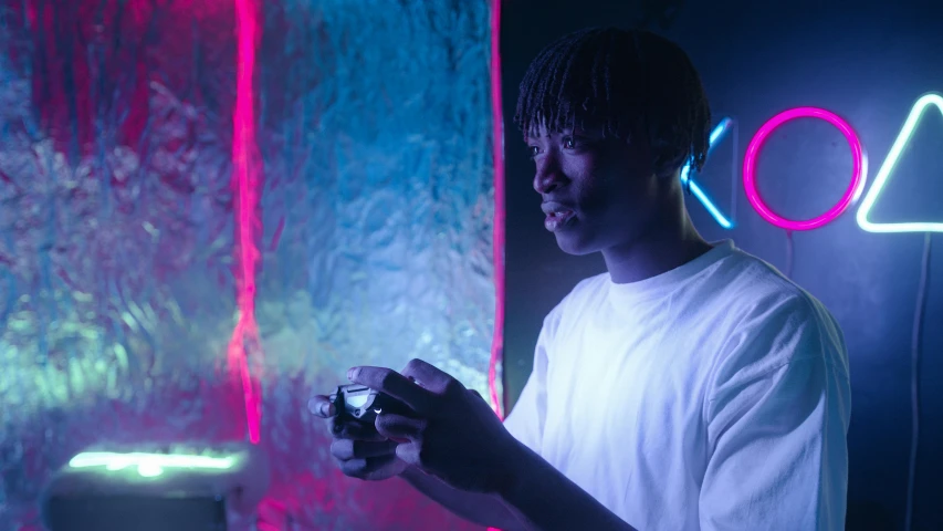 a man holding a video game controller in front of a neon sign, a hologram, pexels contest winner, afrofuturism, black teenage boy, underexposed lighting, lil uzi vert, looking at his phone