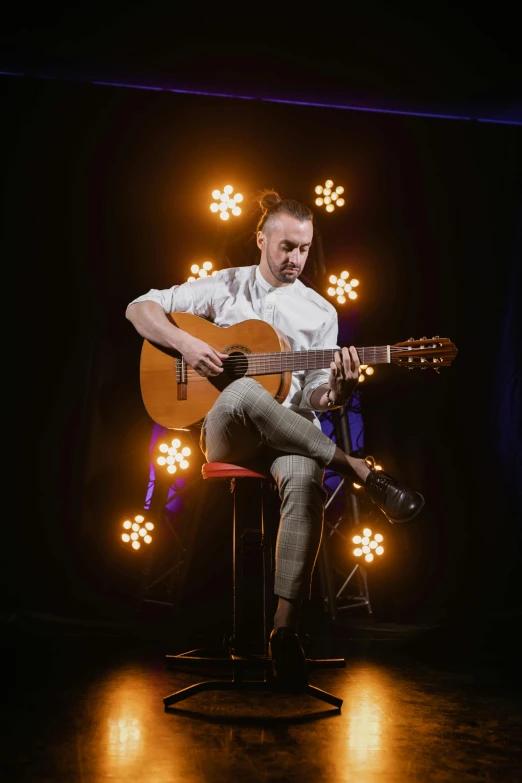 a man sitting on a stool playing a guitar, inspired by Jóhannes Geir Jónsson, antipodeans, light show, portrait photo of a backdrop, solid background, artem