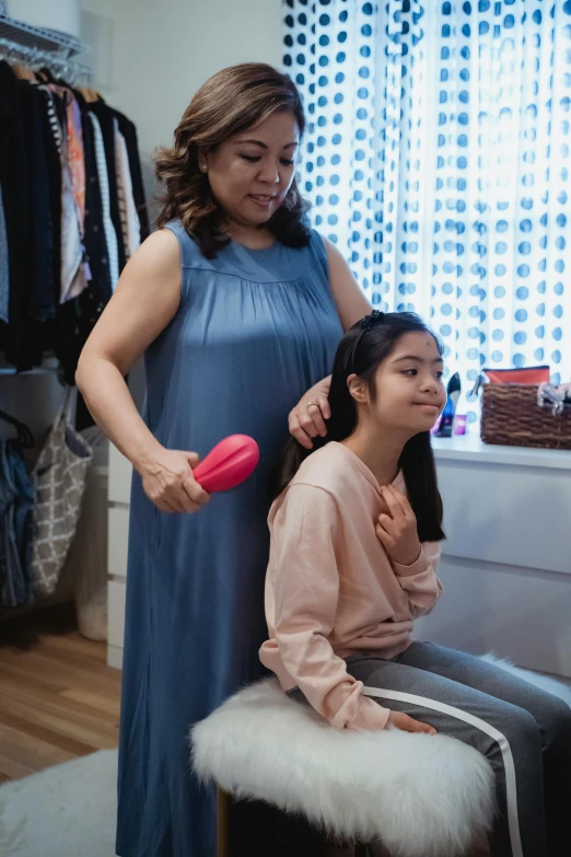 a woman combing another woman's hair in a dressing room, happening, family friendly, joy ang, squishy, product introduction photos