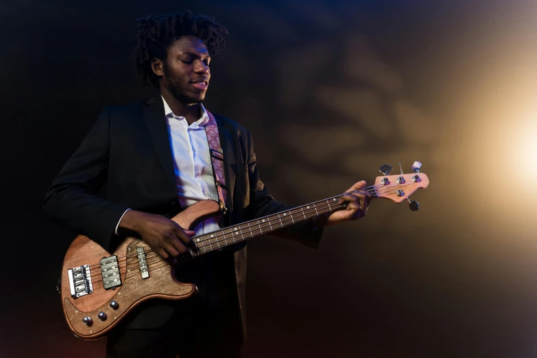 a man in a suit playing a bass guitar, by Stokely Webster, pexels contest winner, a black man with long curly hair, coloured photo, lachlan bailey, riyahd cassiem