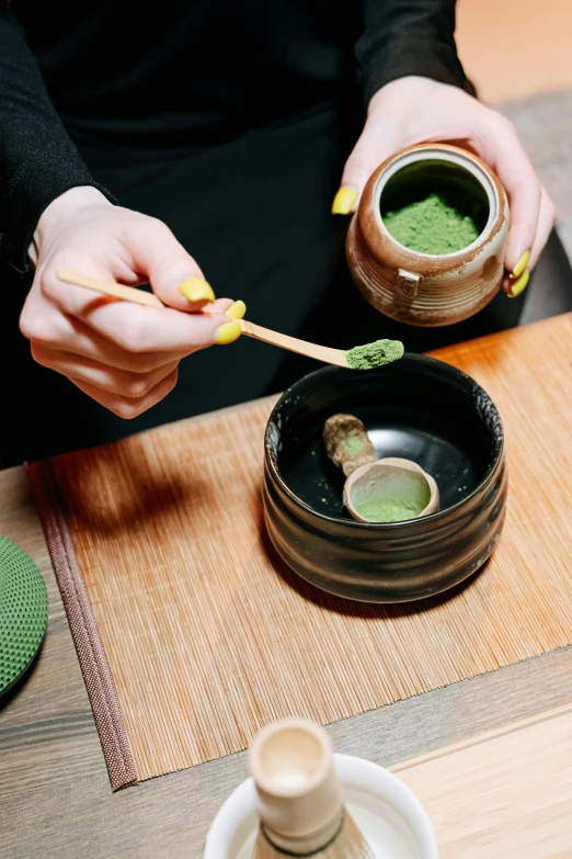 a person holding a spoon over a bowl of green tea, mortar and pestle, sushi, deep green, thumbnail