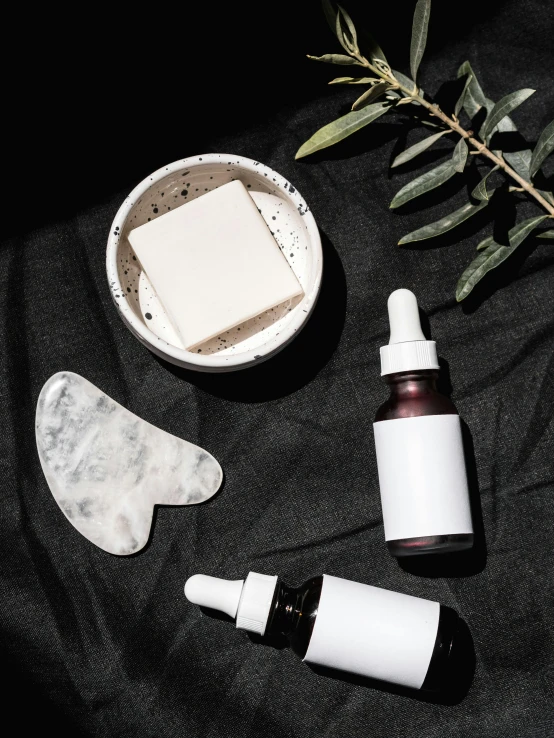 a couple of bottles sitting on top of a table, skincare, organic shapes, black, thumbnail