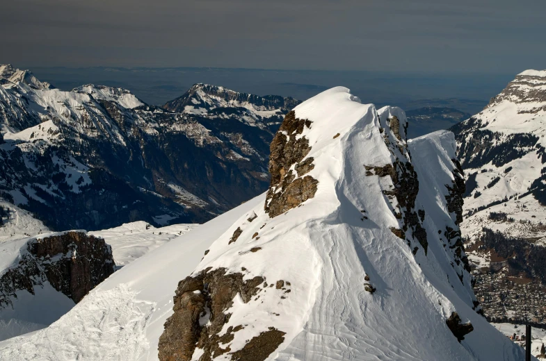 a man riding skis on top of a snow covered mountain, by Peter Churcher, pexels contest winner, les nabis, “ aerial view of a mountain, geiger, large overhangs, high details photo