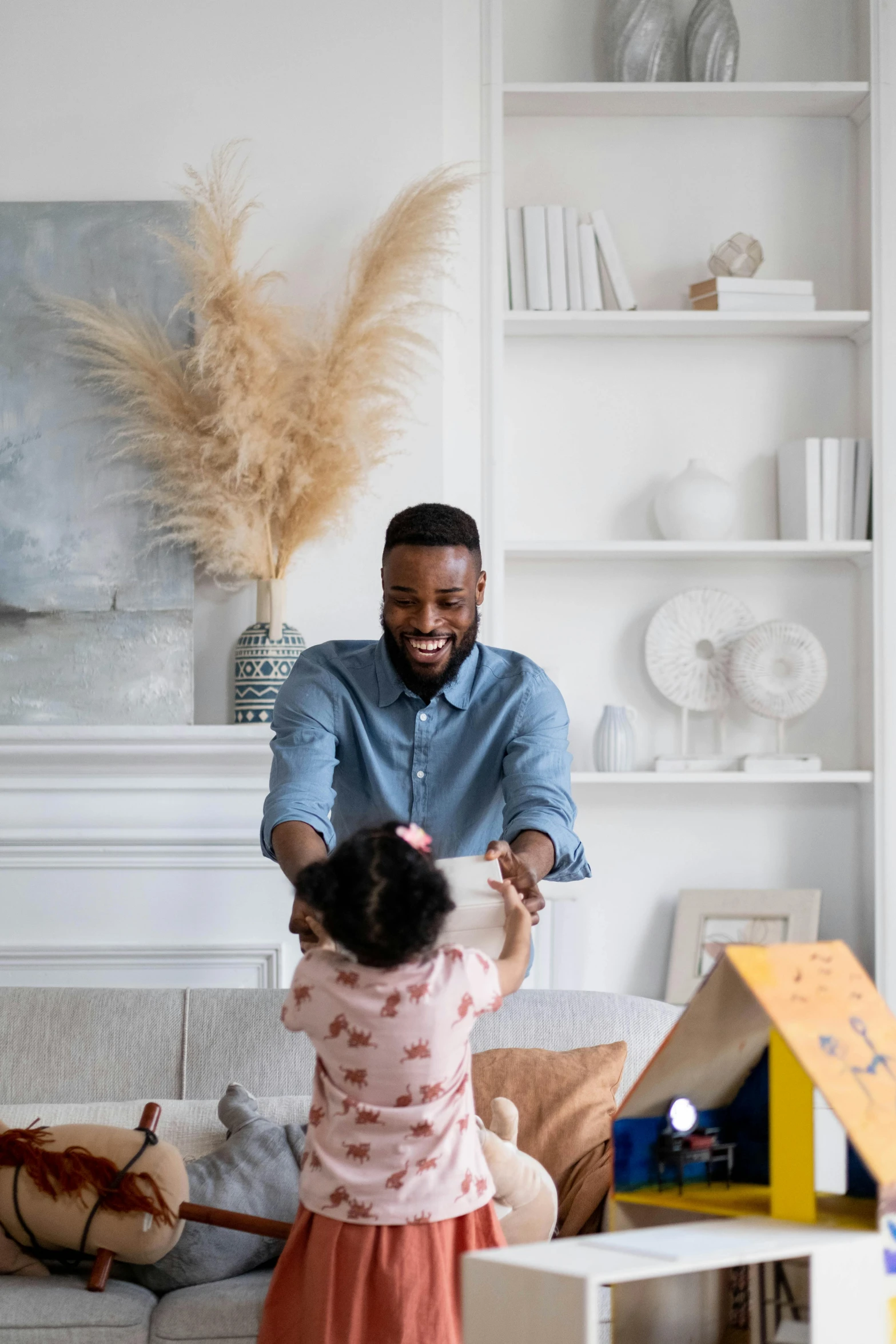 a man standing next to a little girl in a living room, free spaces, black man, rectangle, playful