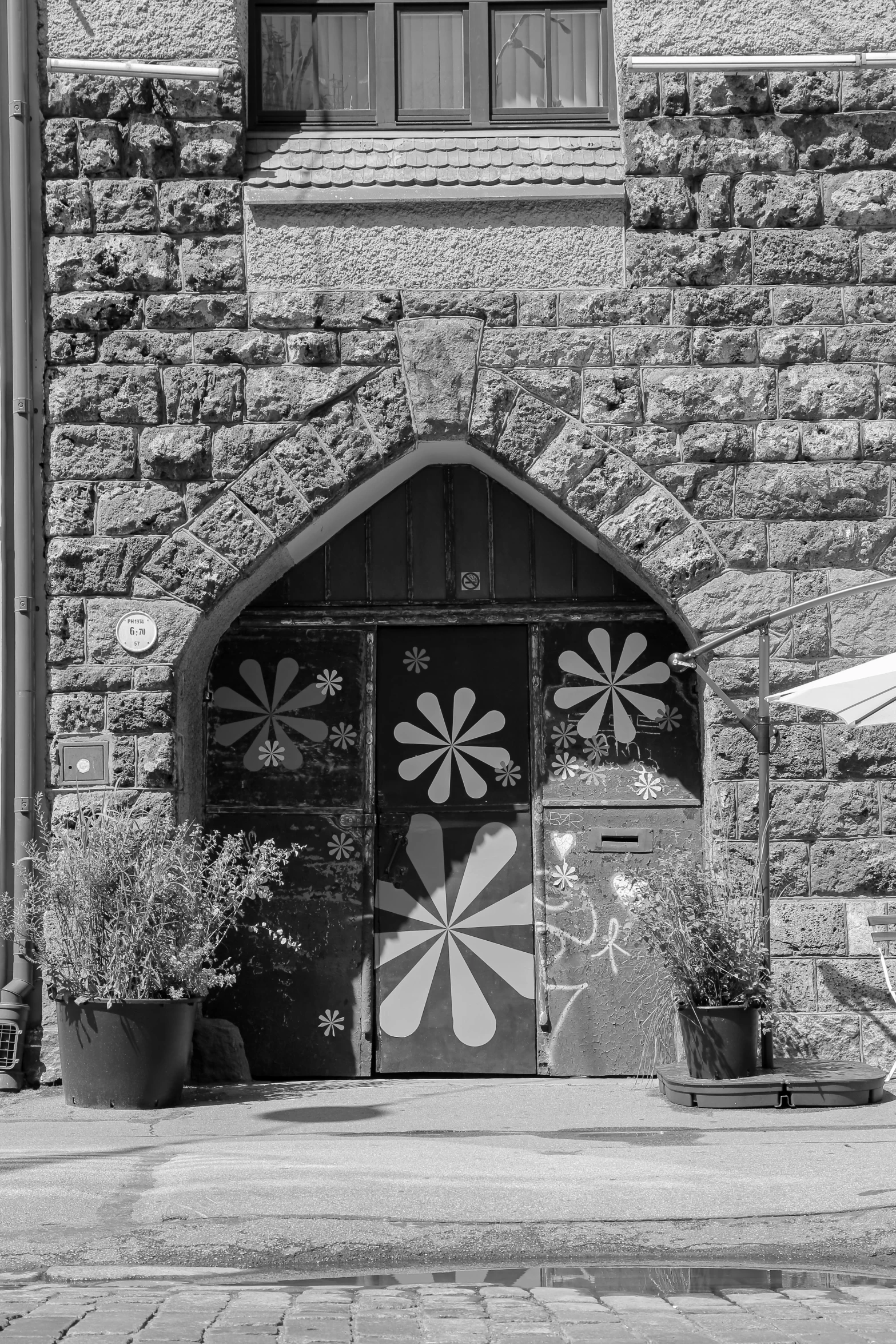 a black and white photo of a building, a black and white photo, flickr, romanesque, 1960s flower power hippy, magic doorway, f / 1. 9 6. 8 1 mm iso 4 0, bakery