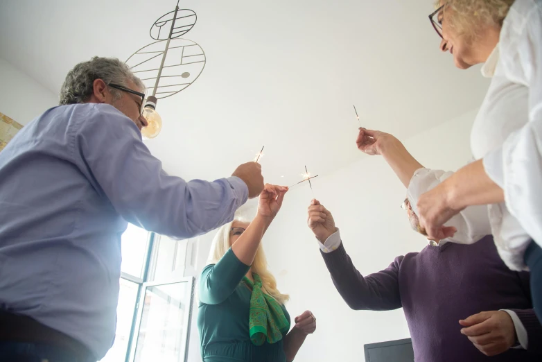 a group of people holding sparklers in their hands, figuration libre, holding a candle holder, people at work, neuroscience, soft natural light