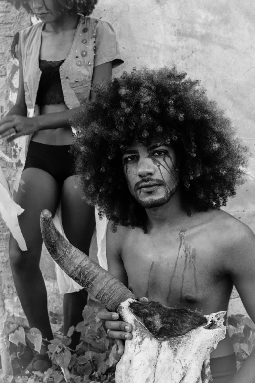 a black and white photo of a man and a woman, inspired by Candido Bido, black arts movement, with snakes for hair, imaan hammam, brazil carnival, on an island