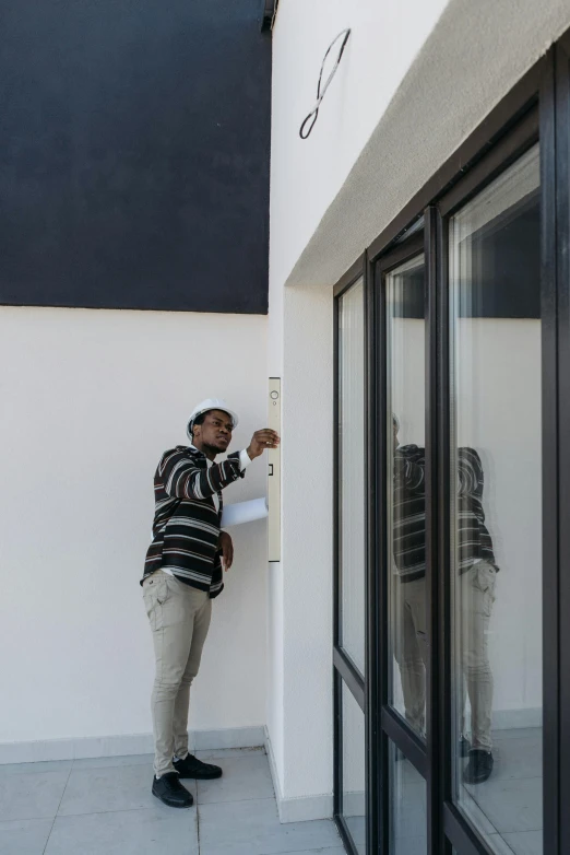 a man that is standing in front of a building, letterbox, sketching, white building, architectural finishes