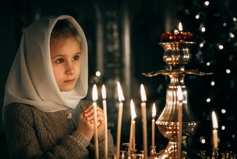 a little girl lighting candles in a church, a portrait, by Julia Pishtar, shutterstock, russian clothes, grey, [ cinematic, orthodox