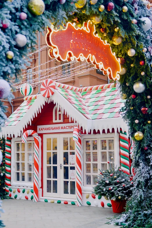 the entrance to a candy shop decorated for christmas, a photo, by Julia Pishtar, red square, orange and white color scheme, against a winter garden, in moscow centre