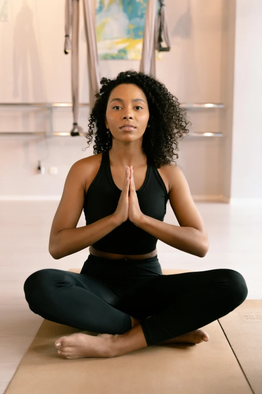 a woman sitting in the middle of a yoga pose, by Carey Morris, trending on pexels, renaissance, african american woman, low quality photo, thumbnail, inviting posture