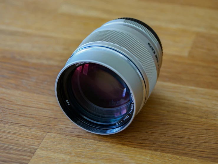 a camera lens sitting on top of a wooden table, by Niels Lergaard, 350mm f/1.4l lens, hyperrealistic n- 4