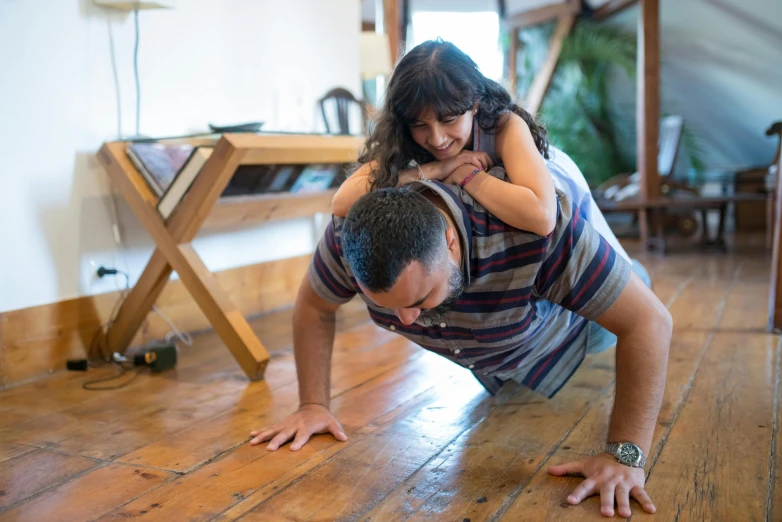 a man and a woman doing push ups on a wooden floor, by Jessie Algie, pexels contest winner, hurufiyya, caring fatherly wide forehead, hispanic, kids playing, lizard pose