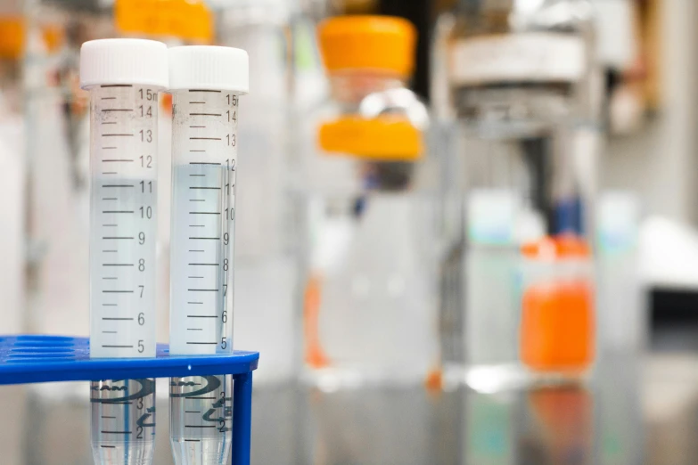 a row of test tubes sitting on top of a table, on a advanced lab, sterile colours, medical labels, waist up