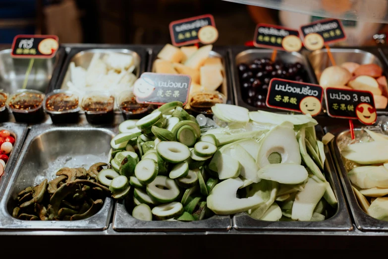 a display case filled with lots of different types of food, unsplash, mingei, background image, black and green scheme, patiphan sottiwilaiphong, food court