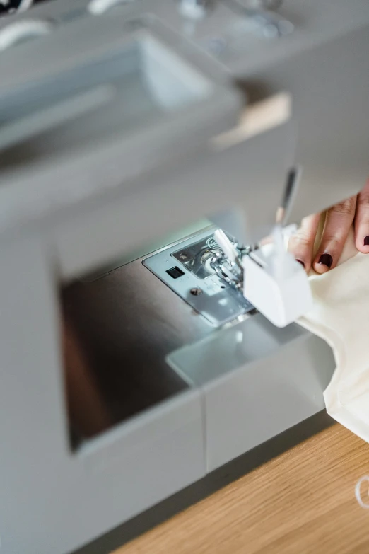 a close up of a person using a sewing machine, wearing silver silk robe, diaper disposal robot, curated collections, white